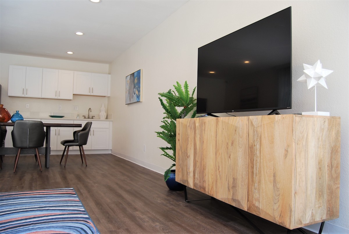 Community clubhouse, looking at the flatscreen TV with the kitchenette in the background.